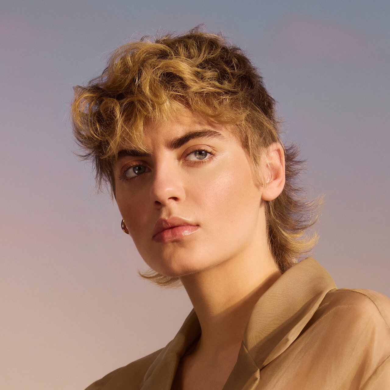 Porträt einer jungen Frau mit stufigem Kurzhaarschnitt in Blond- und Brauntönen