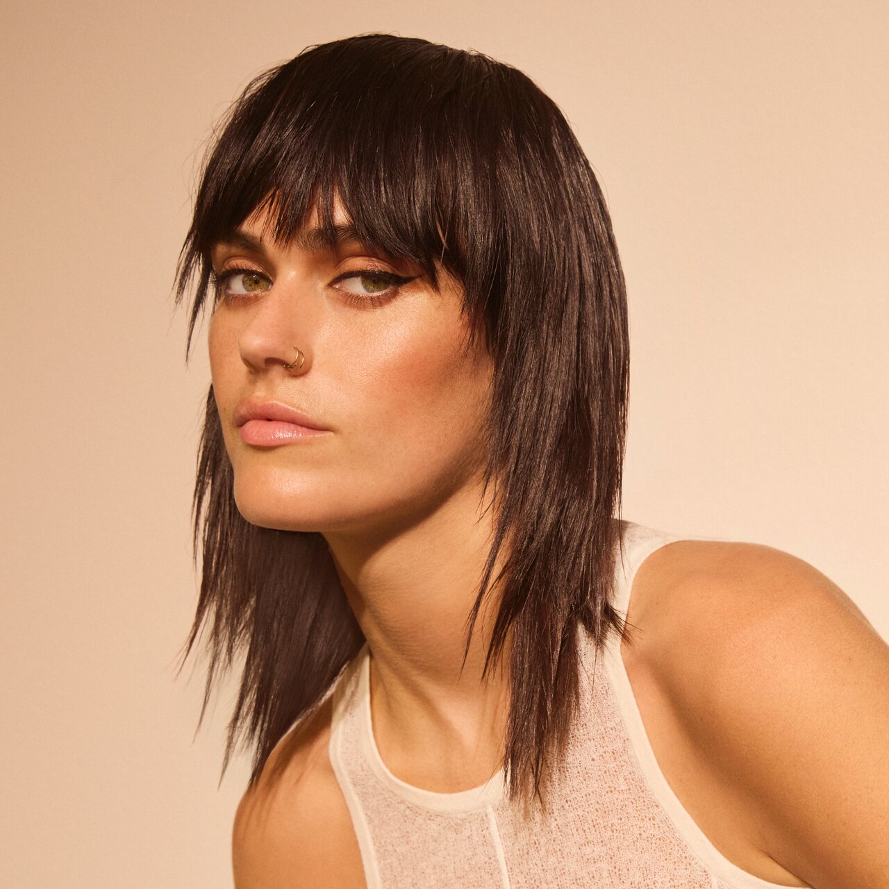 Porträt einer jungen Frau, die einen brünetten Mullet trägt, die Haare sind geglättet