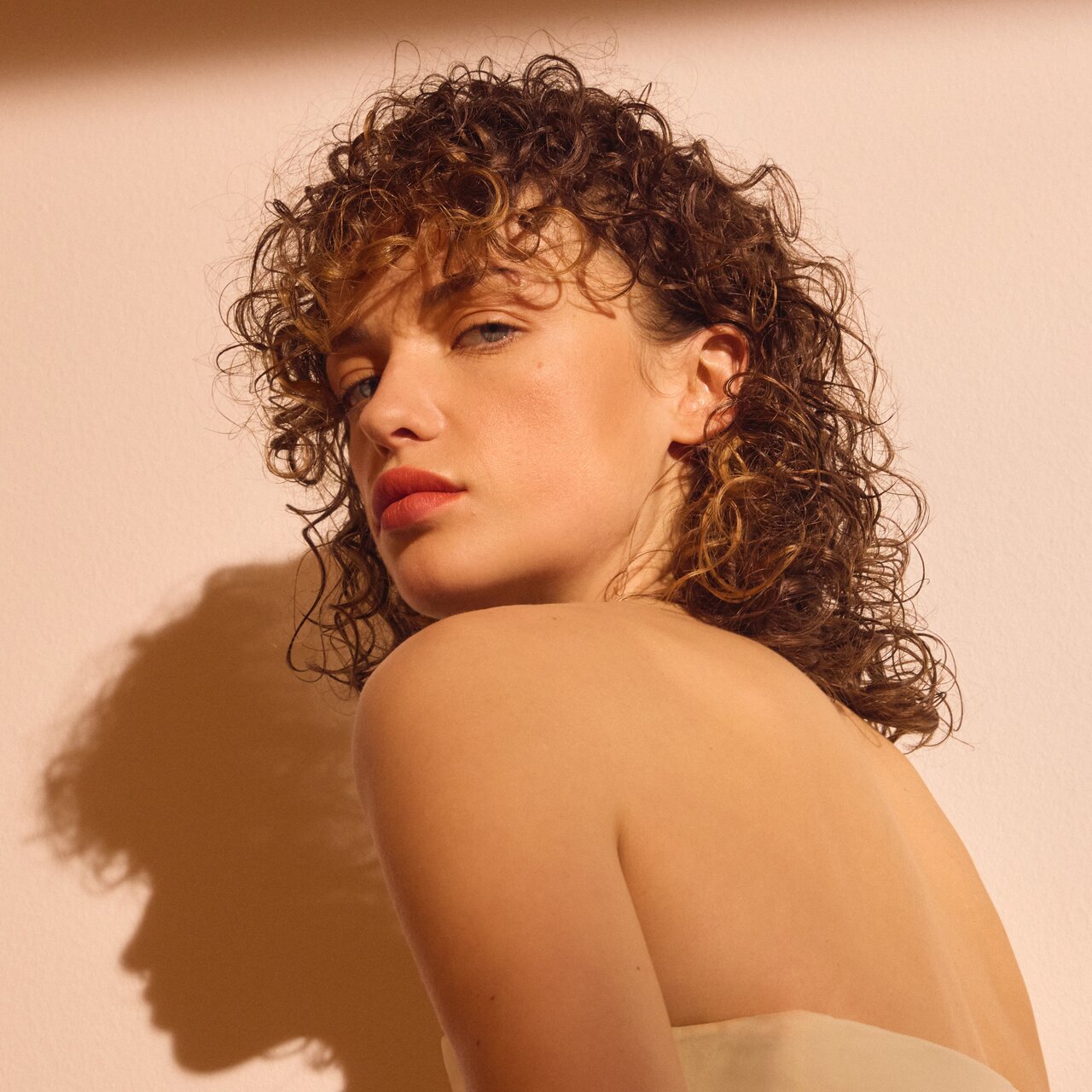 Eine junge Frau mit braunem gelocktem Haar, das im Wet-Look gestylt ist