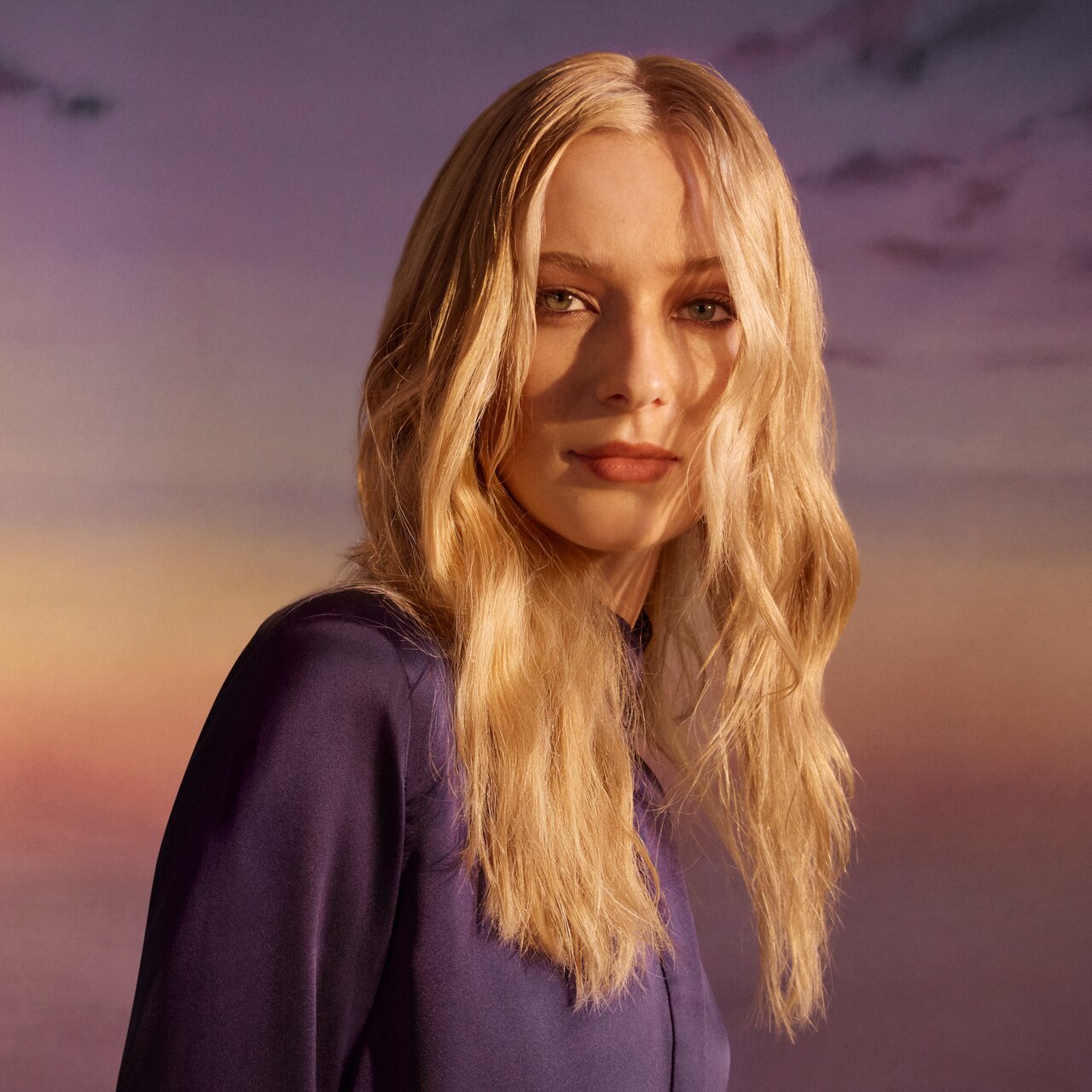 Porträt einer jungen Frau mit langen blonden Haaren, wellig im Wet-Look gestylt