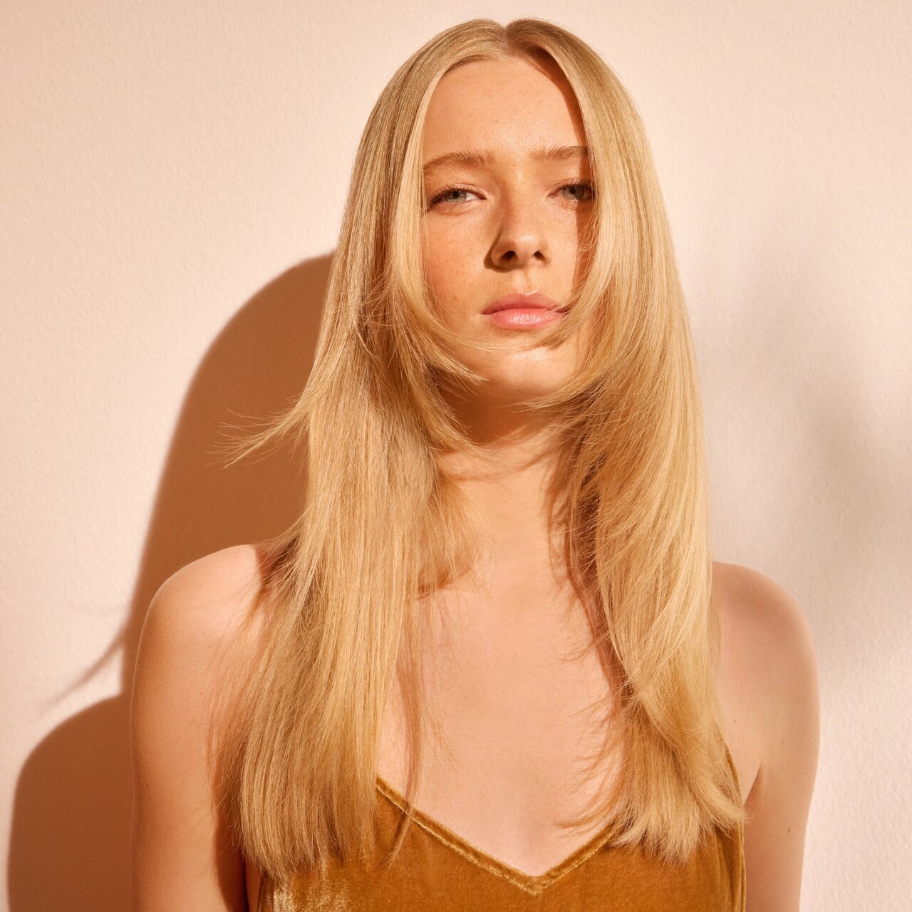 Porträt einer natürlich geschminkten jungen Frau mit langen blonden Haaren im Stufenschnitt