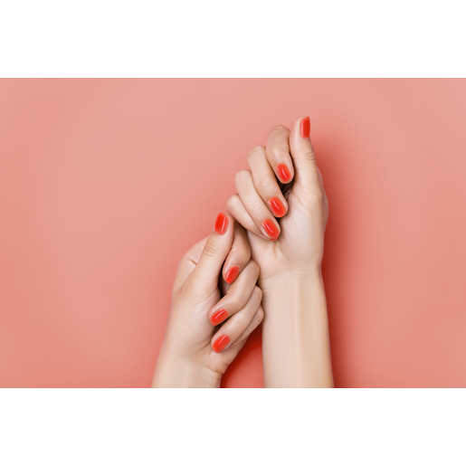 Nahaufnahme von zwei schönen Händen einer Frau mit orange lackierten Fingernägeln, die den Make-up Trend „Jelly Nails“ repräsentieren