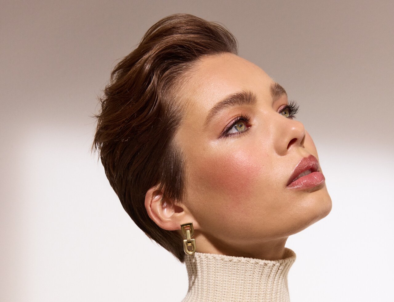 Junge schöne Frau im Profil mit glitzerndem Lidschatten in Bronze präsentiert den Lidschatten Trend 2025 2026 Rustic Charm