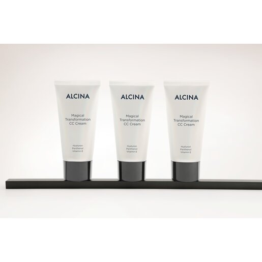 Drei Tuben ALCINA Magical Transformation CC Cream mit Hyaluron, Panthenol und Vitamin E stehen nebeneinander auf einer dunklen Leiste vor hellem Hintergrund.