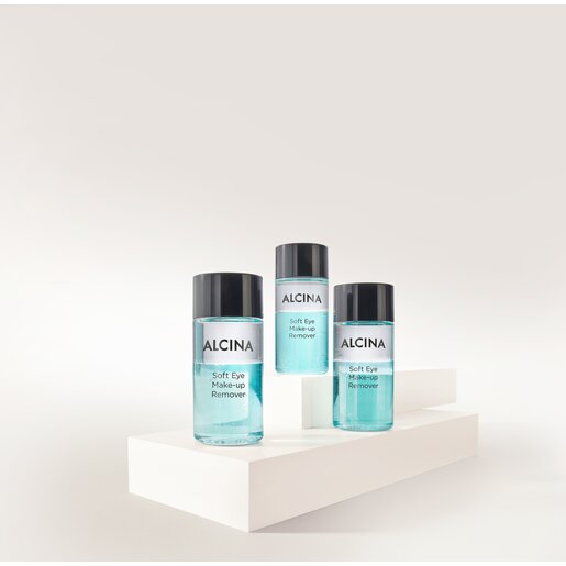 ALCINA Soft Eye Make-up Remover in drei transparenten Flaschen mit zweiphasiger, türkisfarbener Formulierung, auf weißen Podesten arrangiert für sanftes und gründliches Entfernen von Augen-Make-up.