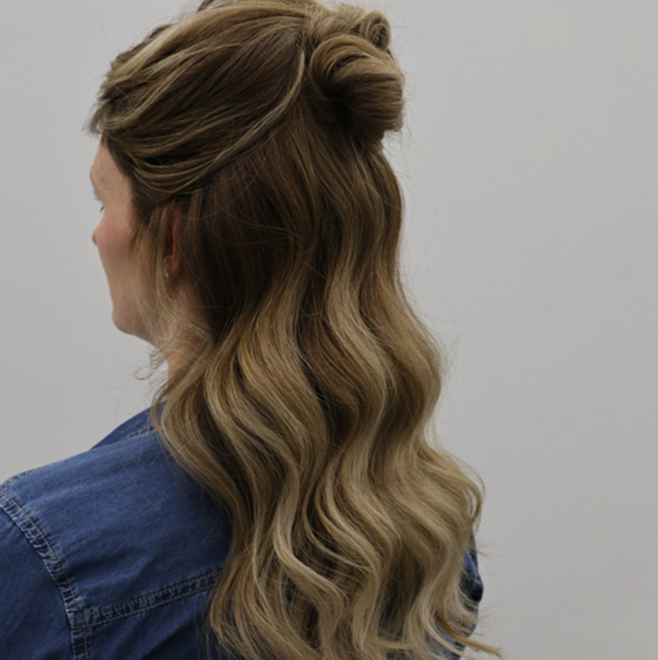 ALCINA Balayage in dunkelblond und gold erinnert farblich an ein Tigerauge Halbportrait einer Frau von schräg hinten mit Langhaarfrisur in tigereye Balayage dunkelblond–Technik gefärbt