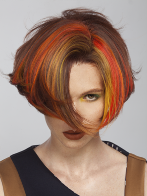 Portrait einer Frau mit kurzer Bob-Frisur und gefärbten Blocksträhnen als Chunky Highlights in Orange,  Rot und Gelb