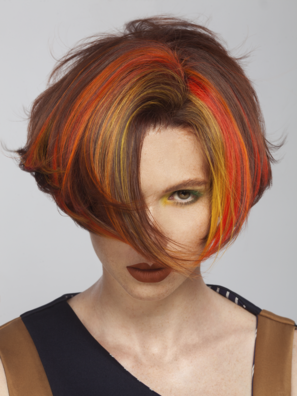 ALCINA Haarfärbetechnik Chunky Highlights Blocksträhnen mit eindrucksvoll bunten Kontrasten Portrait einer Frau mit kurzer Bob-Frisur und gefärbten Blocksträhnen als Chunky Highlights in Orange, Rot und Gelb
