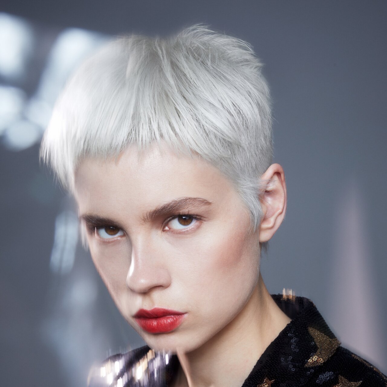 Porträt einer schönen jungen Frau, die die Trend-Haarfarbe Platinblond mit einem sehr kurzen Pixie präsentiert