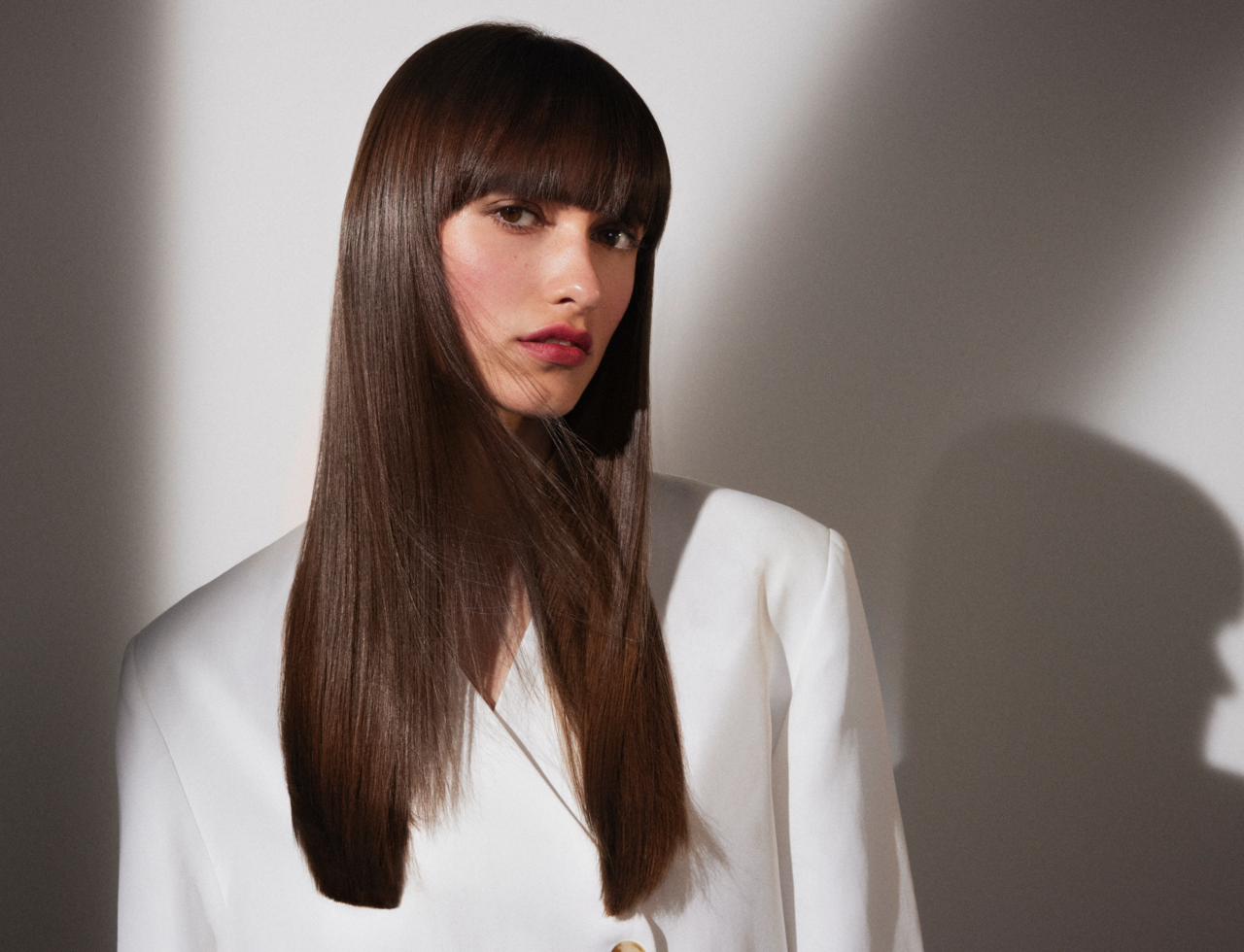 Schöne, junge Frau mit langen, dunkelbraunen Haaren, die ihr offen und glänzend über Ihre Schultern fallen.