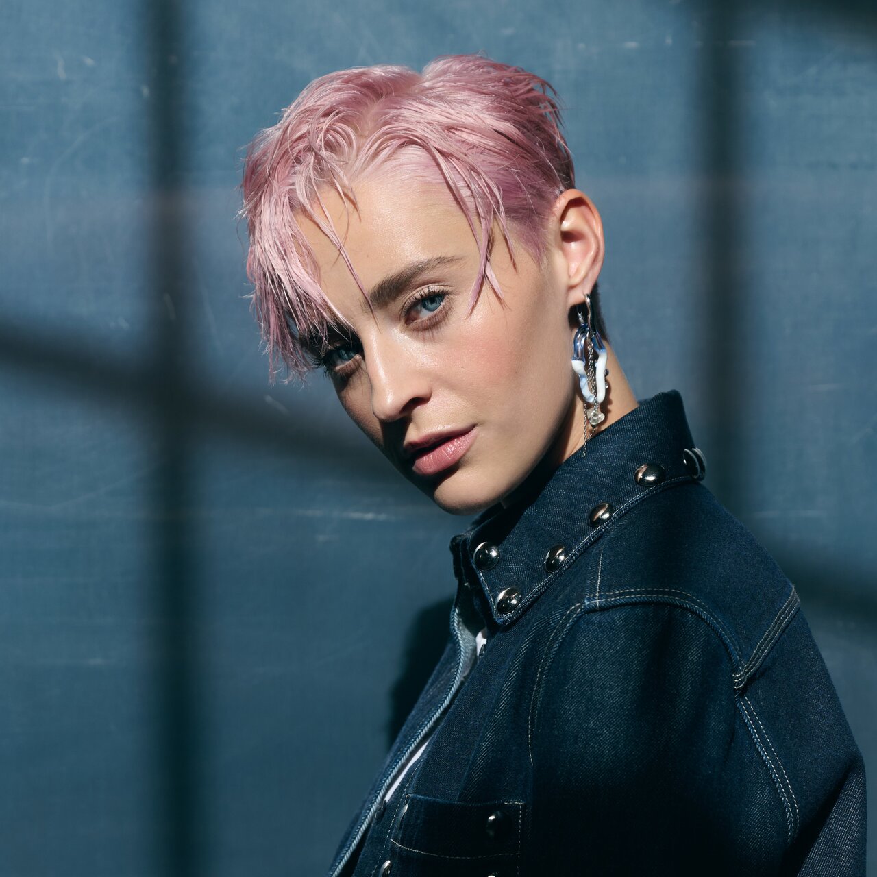 Porträt einer Frau mit rosafarbener Kurzhaarfrisur im Wet Look