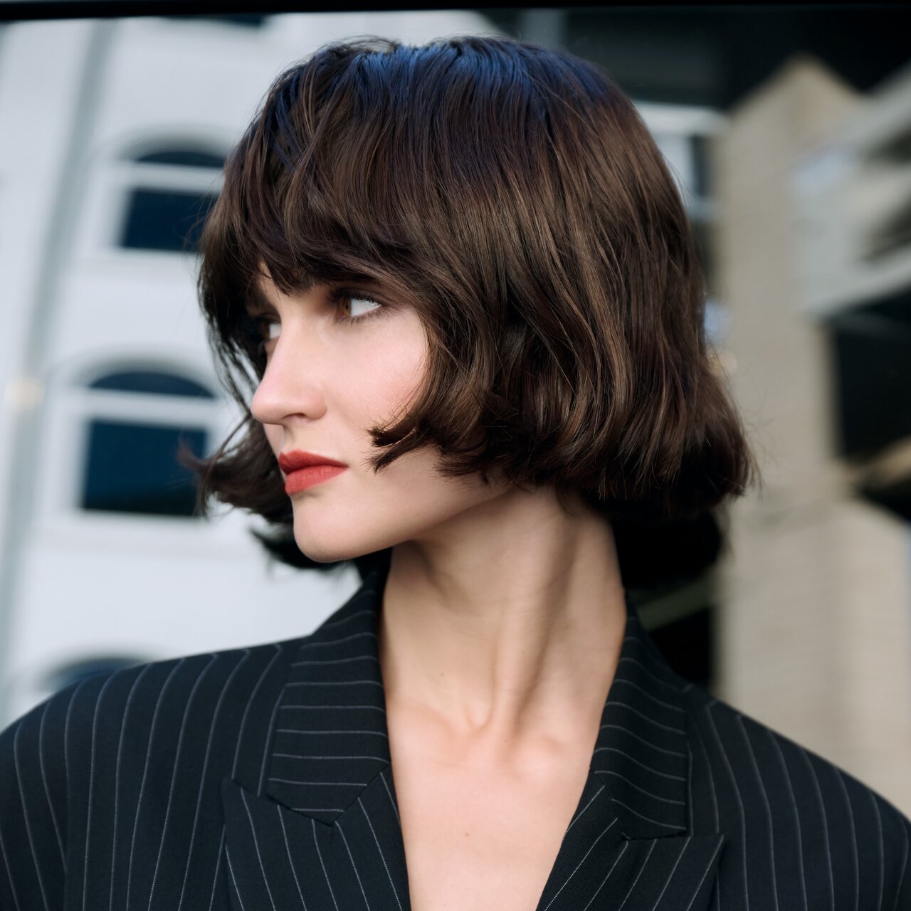 Porträt einer brünetten Frau mit schwungvoll gestyltem Bob