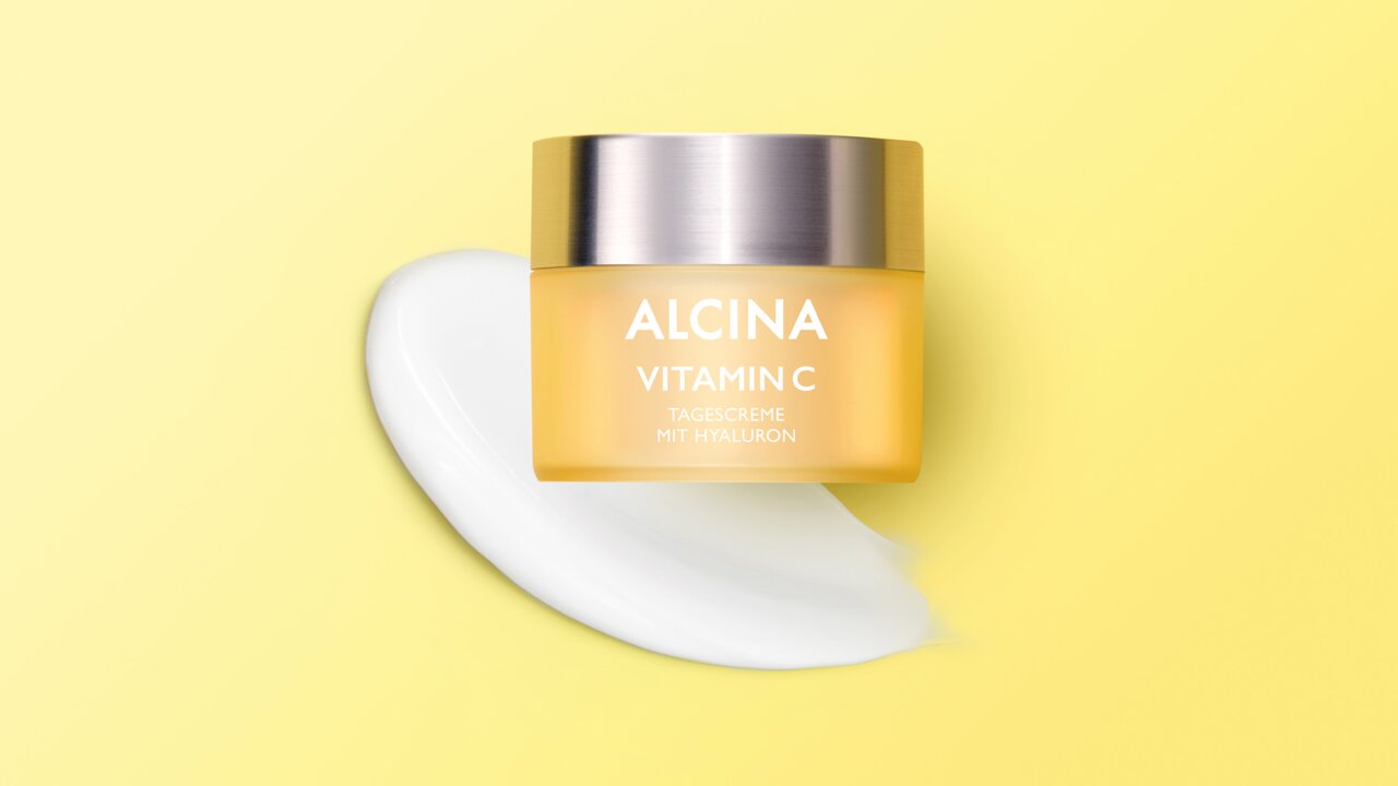 ALCINA Vitamin C Tagespflege enthält wertvolles Vitamin C und ausgesuchte Pflegestoffe wie Hyaluron und Traubenkernöl ALCINA Vitamin C Tagespflege Tiegel vor einem ausgestrichenen Cremeklecks