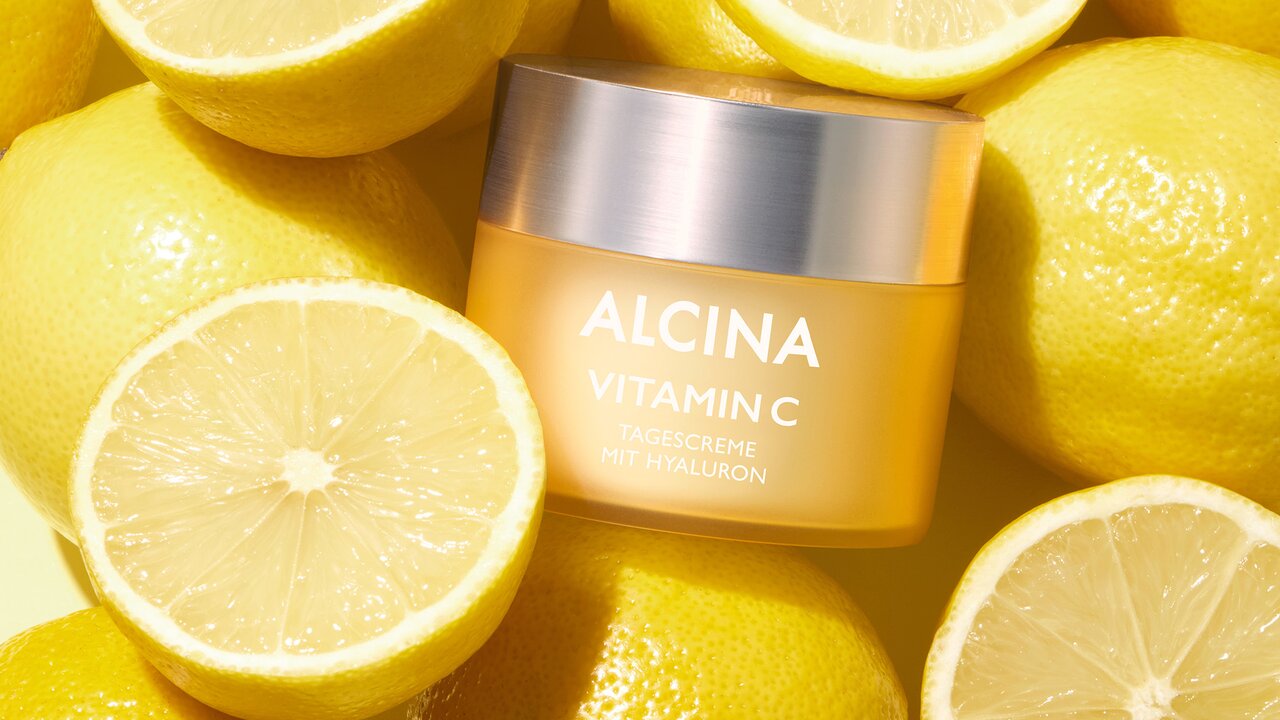 Aufgeschnittene Zitronen mit einem Tiegel der ALCINA Vitamin C Creme in der Mitte platziert