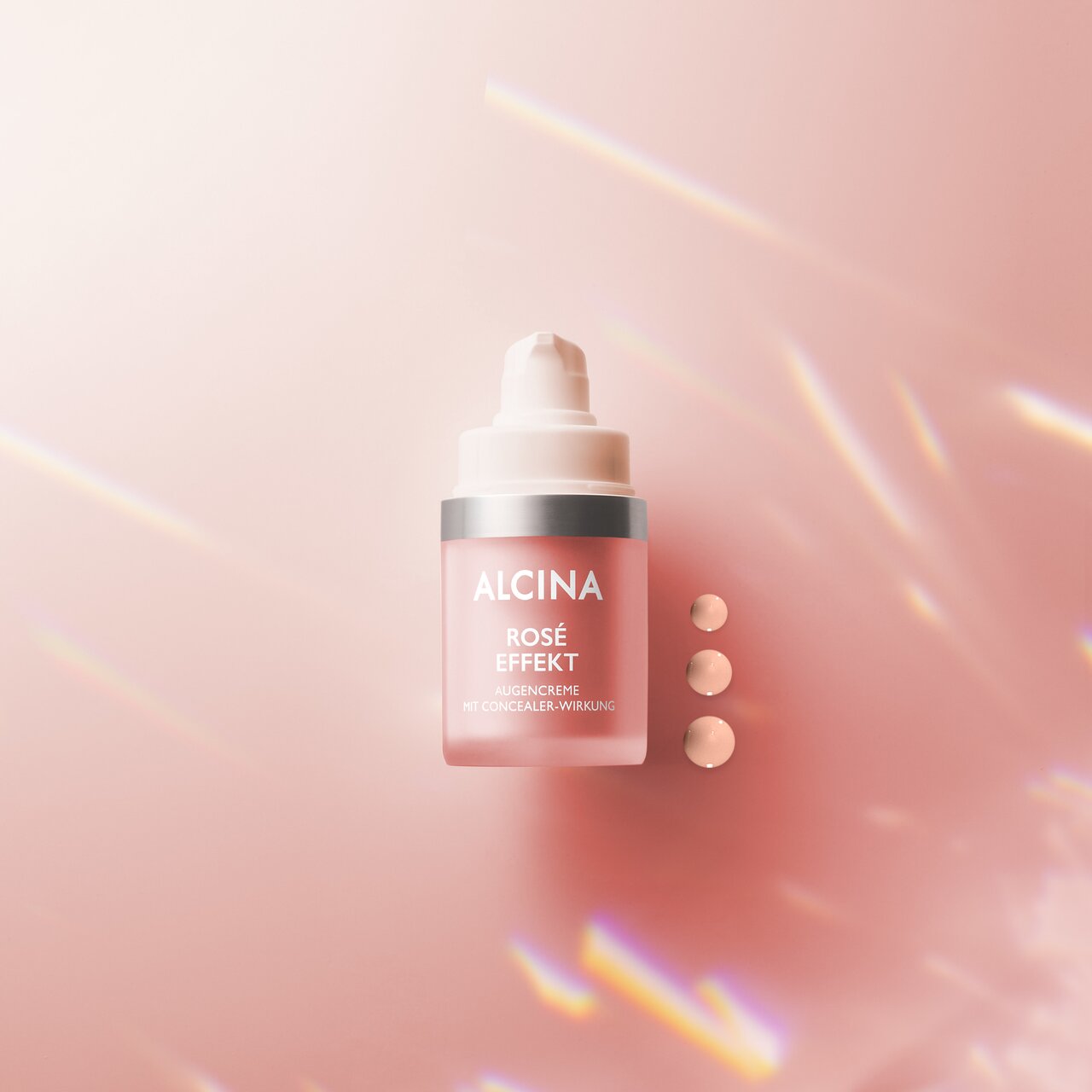 Ein offener Pumpspender der ALCINA Rosé Effekt Augencreme. Mehrere rosafarbenen Creme-Punkten zeigen Konsistenz der Creme