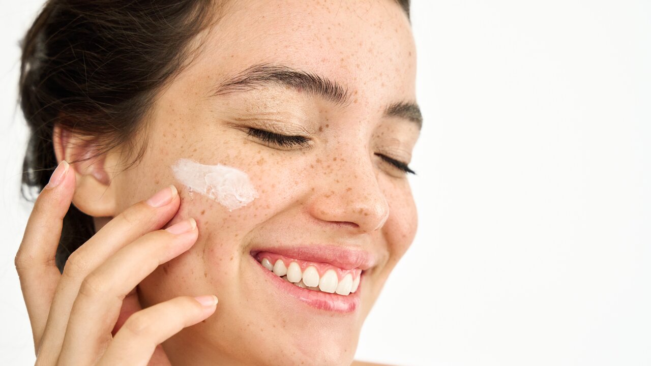 Schöne Frau mit leicht geschwollenen Augenlidern berührt vorsichtig den Bereich um ihre Augen