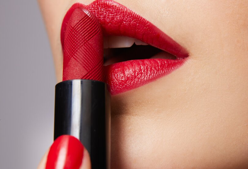 Nahaufnahme einer schönen jungen Frau mit rot geschminkten Lippen in der Trendfarbe Cold Red als Sinnbild für den Make-up-Trend Bold Red Lips im Herbst Winter 2023
