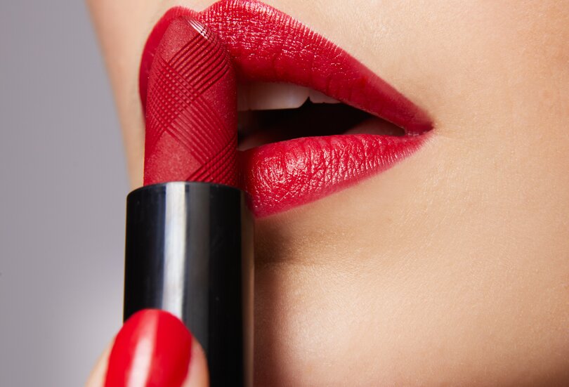 Ein auffälliger roter Lippenstift macht den gesamten Look direkt zu einem wahren Hingucker Nahaufnahme einer schönen jungen Frau mit rot geschminkten Lippen in der Trendfarbe Cold Red als Sinnbild für den Make-up-Trend Bold Red Lips im Herbst Winter 2023