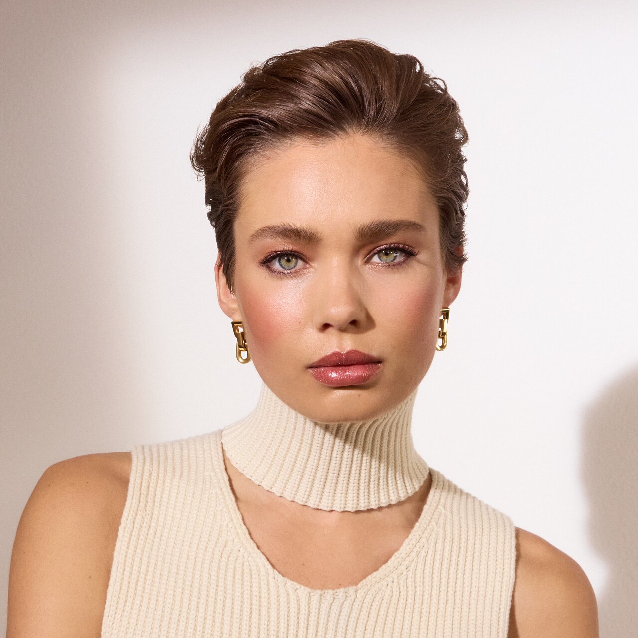 Schöne junge Frau mit dezentem Make-up schaut leicht lächelnd direkt zum Betrachter.