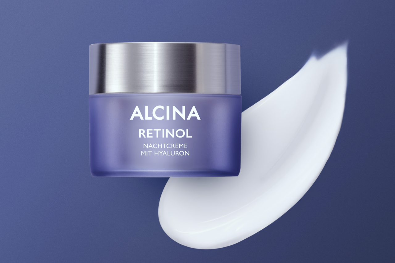 ALCINA Retinol-Creme beinhaltet hochwertig verkapseltes Retinol sowie Pflegestoffe wie Hyaluron und Sheabutte Tiegel ALCINA Retinol Nachtcreme mit Hyaluron und Darstellung der cremigen Textur auf blau violettem Hintergrund